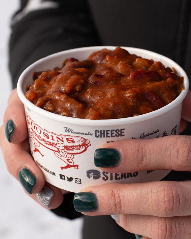 Hands holding cup of chili